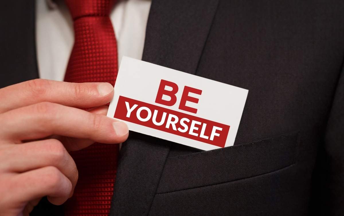 Be Yourself At Work. Close-up of business man pulling out business card that says "Be Yourself"